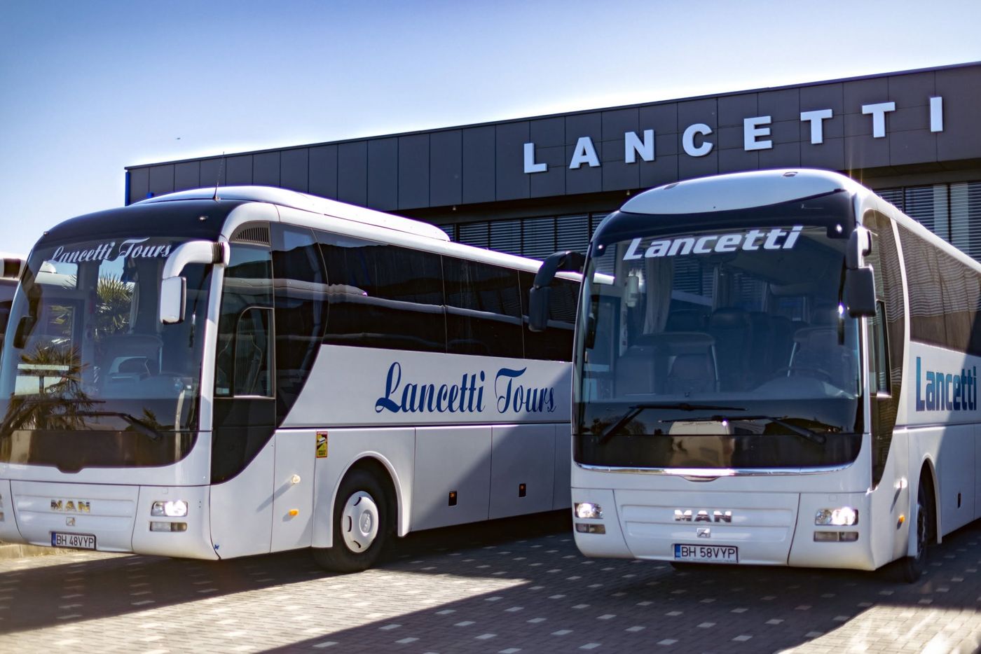 Membru al echipei Lancetti Tour în fața autocarelor